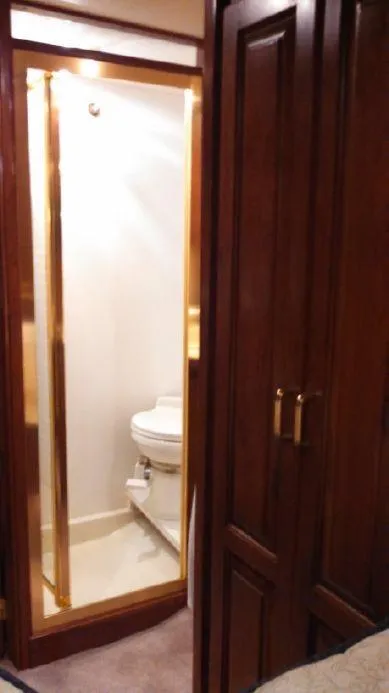 Slide: The Image of 1973 Trojan F-32 yacht bathroom with wooden door and compact toilet. - 13