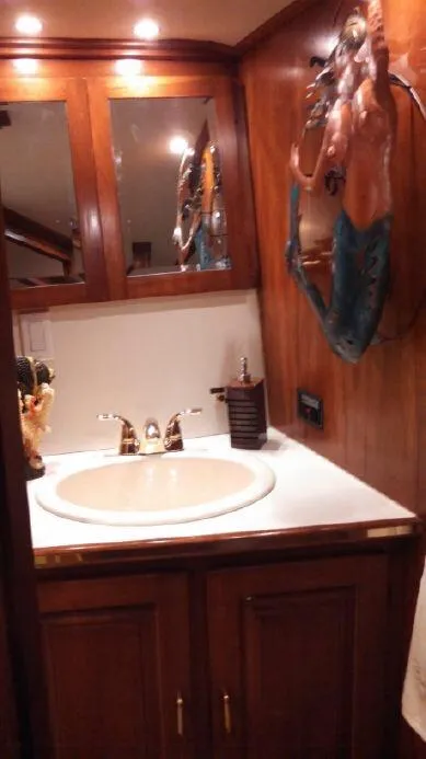 Slide: The Image of 1973 Trojan F-32 yacht bathroom with wooden cabinets and decorative wall art. - 14