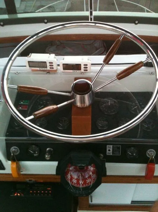 Slide: The Image of 1973 Trojan F-32 boat helm with compass, gauges, and wooden-accented steering wheel. - 4