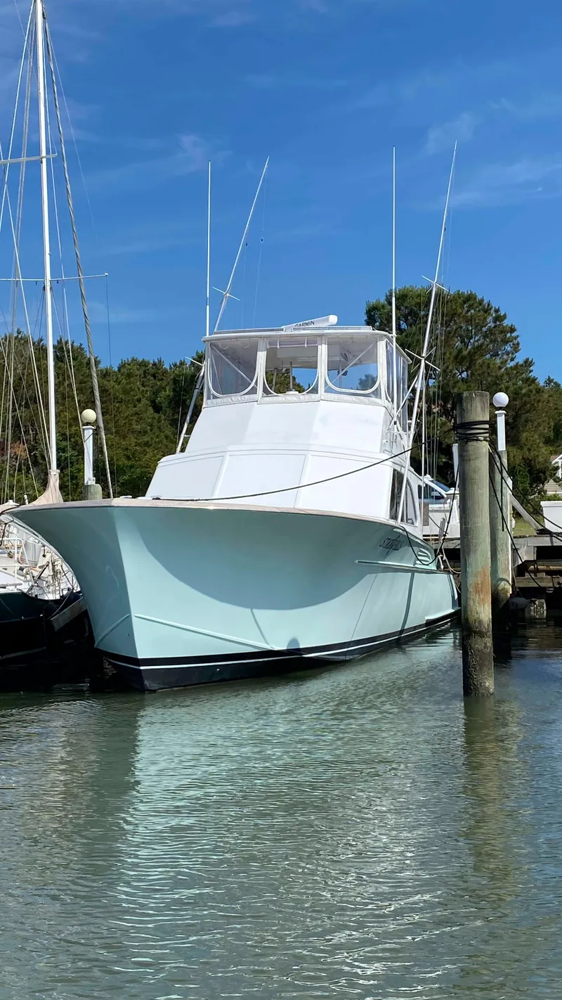 Slide: The Image of 1979 Buddy Davis 46 Convertible yacht docked in a serene marina setting. - 1