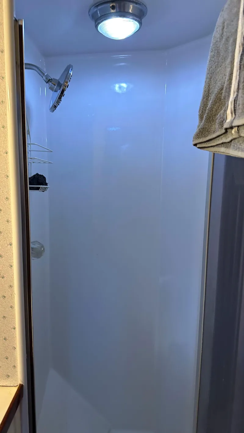 Slide: The Image of Shower area inside a 1979 Buddy Davis 46 Convertible boat, featuring a modern showerhead. - 20