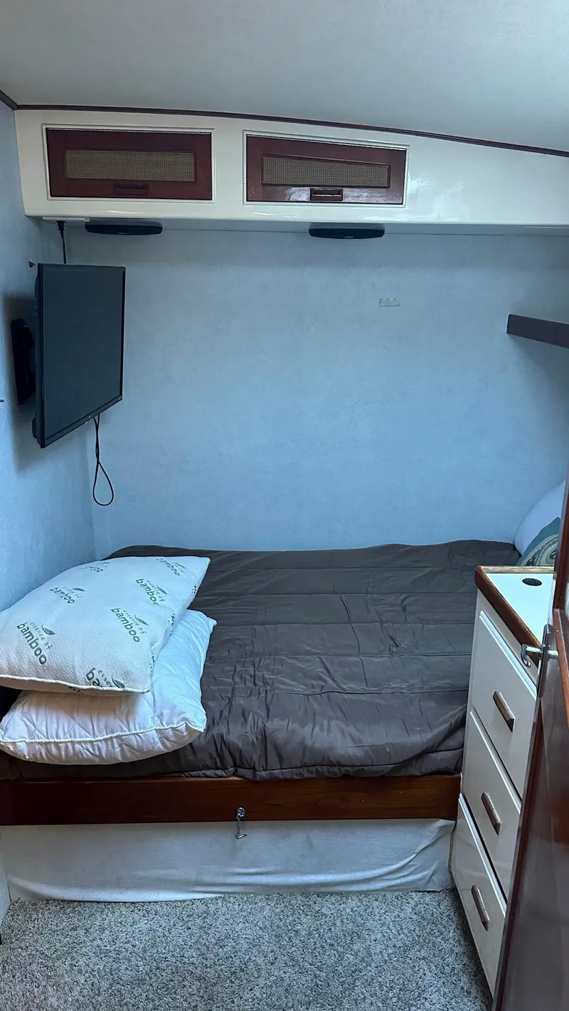 Slide: The Image of 1979 Buddy Davis 46 Convertible cabin interior with bed, TV, and storage cabinets. - 21