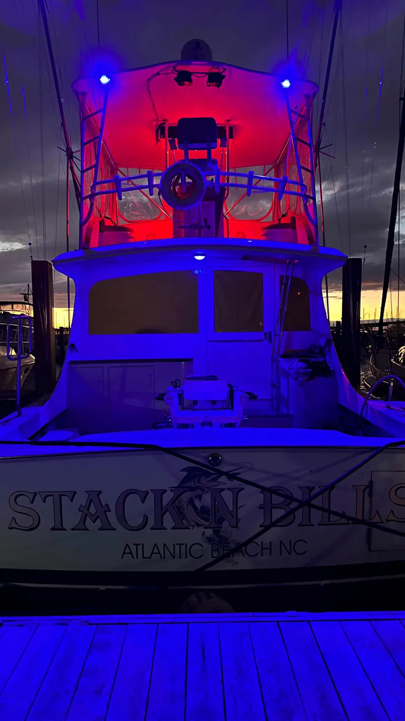 Slide: The Image of 1979 Buddy Davis 46 Convertible boat with vibrant red and blue lighting at sunset. - 8