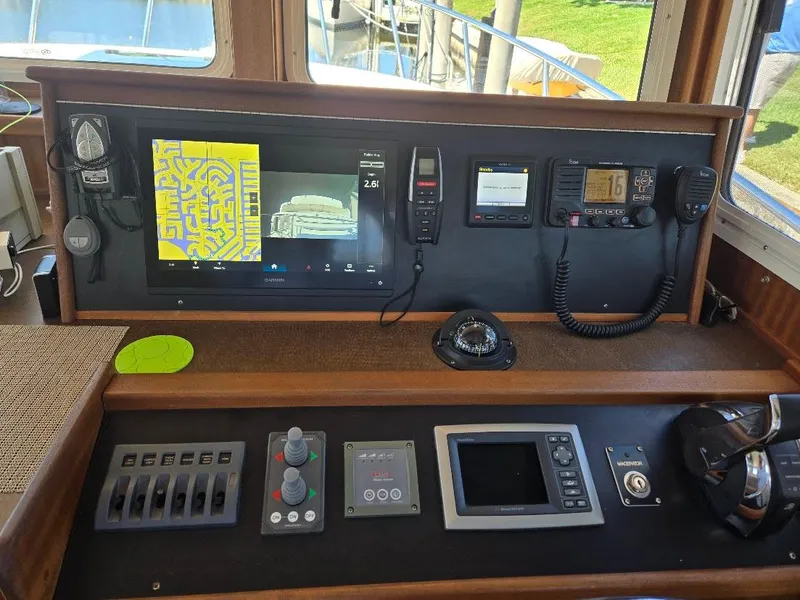 Slide: The Image of Control panel of a 2015 American Tug 365 Flybridge with navigation and communication equipment. - 10