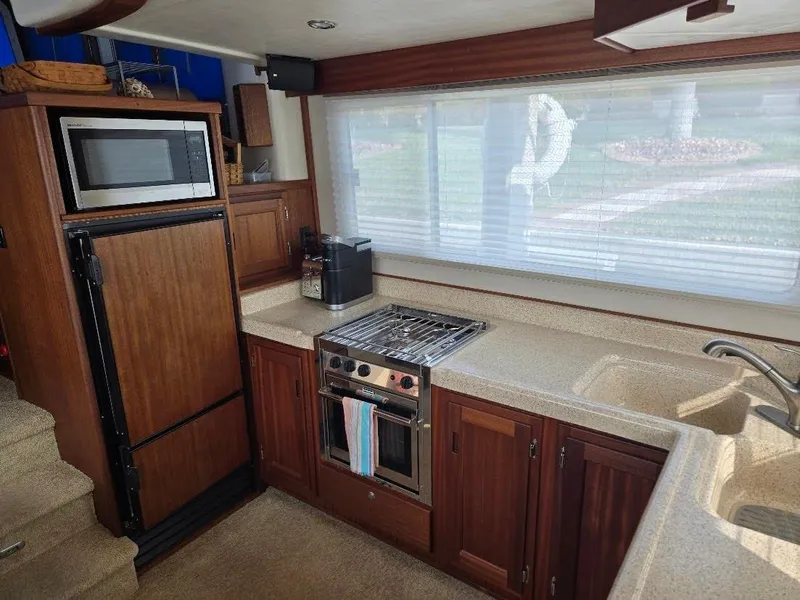 Slide: The Image of Interior of 2015 American Tug 365 Flybridge with kitchen appliances and wooden cabinetry. - 11