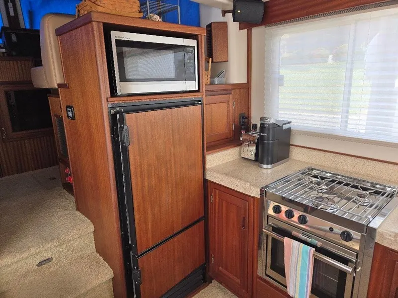 Slide: The Image of Kitchen area of 2015 American Tug 365 Flybridge with appliances and wooden cabinetry. - 13