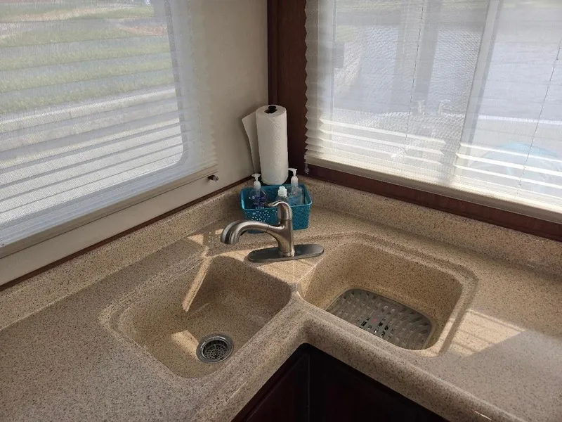 Slide: The Image of Kitchen sink area in 2015 American Tug 365 Flybridge, featuring dual basins and countertop. - 16