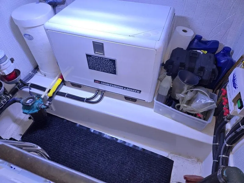 Slide: The Image of Engine room of 2015 American Tug 365 Flybridge with generator and maintenance tools. - 23