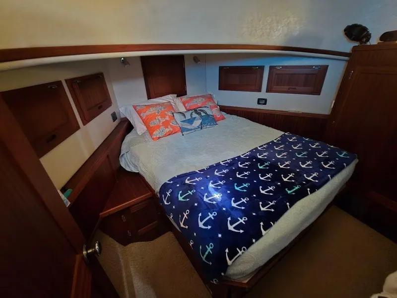 Slide: The Image of Cozy bedroom in 2015 American Tug 365 Flybridge with nautical-themed bedding. - 29