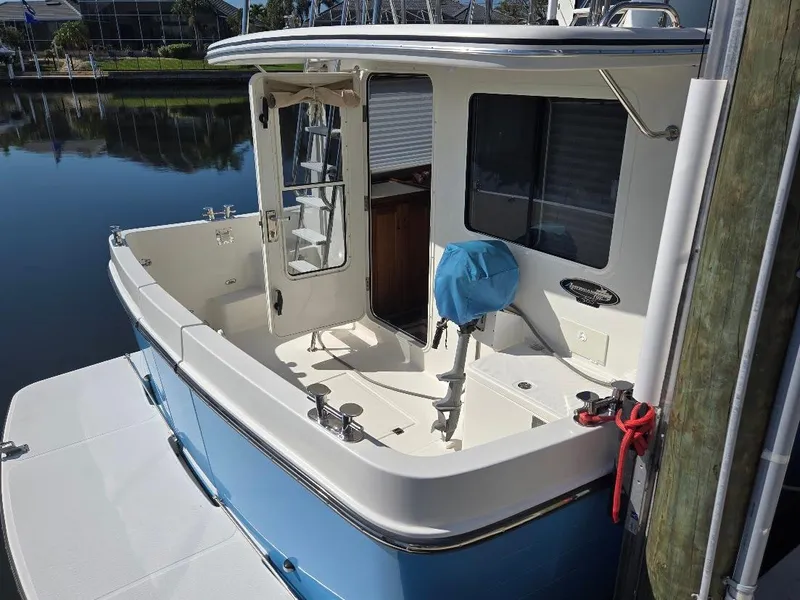 Slide: The Image of 2015 American Tug 365 Flybridge, docked, showcasing spacious deck and sleek design. - 4