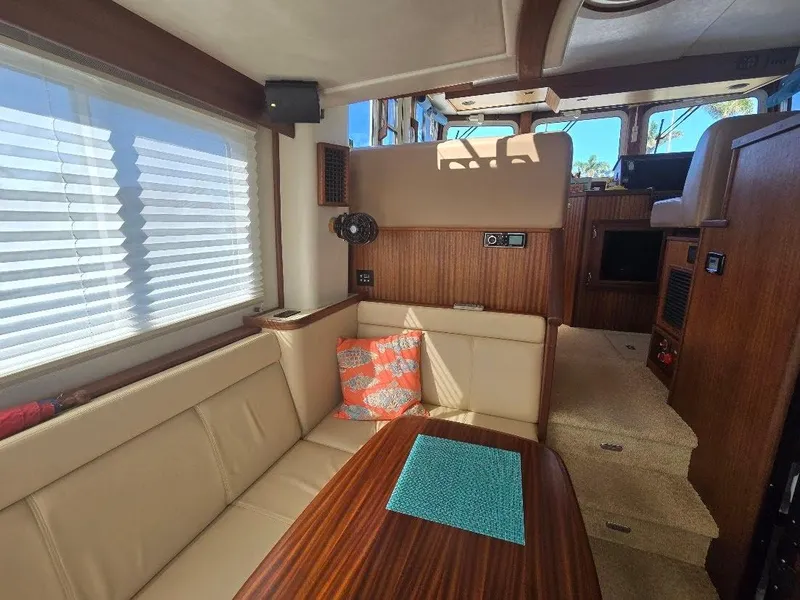 Slide: The Image of Interior of 2015 American Tug 365 Flybridge with beige seating and wooden accents. - 8