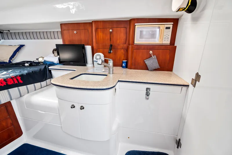 Slide: The Image of 2006 Intrepid 377 WA cabin interior with kitchenette, microwave, and bed. - 10