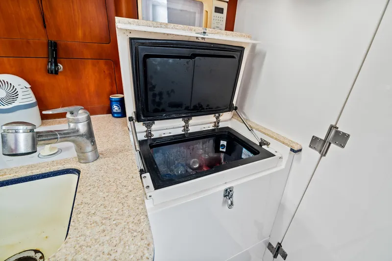 Slide: The Image of Open cooler in 2006 Intrepid 377 WA boat kitchen with countertop and sink. - 11
