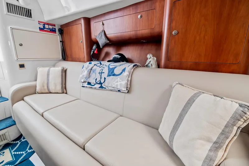 Slide: The Image of Interior of 2006 Intrepid 377 WA boat with beige sofa and nautical decor. - 12