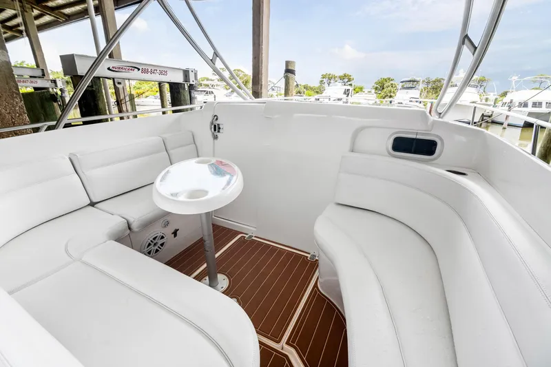 Slide: The Image of 2006 Intrepid 377 WA boat interior with white seating and small table, docked at marina. - 8