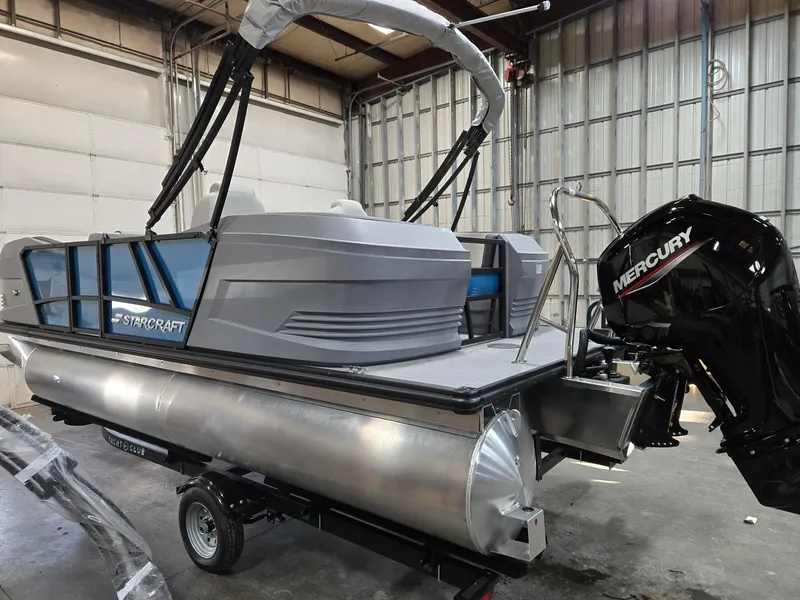 Slide: The Image of 2025 Starcraft GX20R pontoon boat with Mercury engine in a warehouse setting. - 6