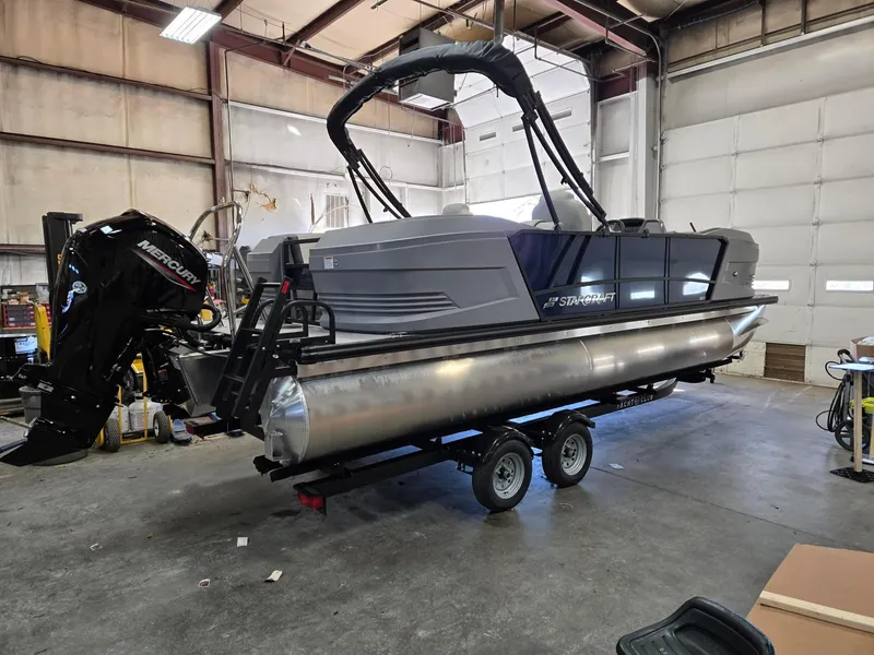 Slide: The Image of 2025 Starcraft GX22R pontoon boat with Mercury engine in a warehouse setting. - 3