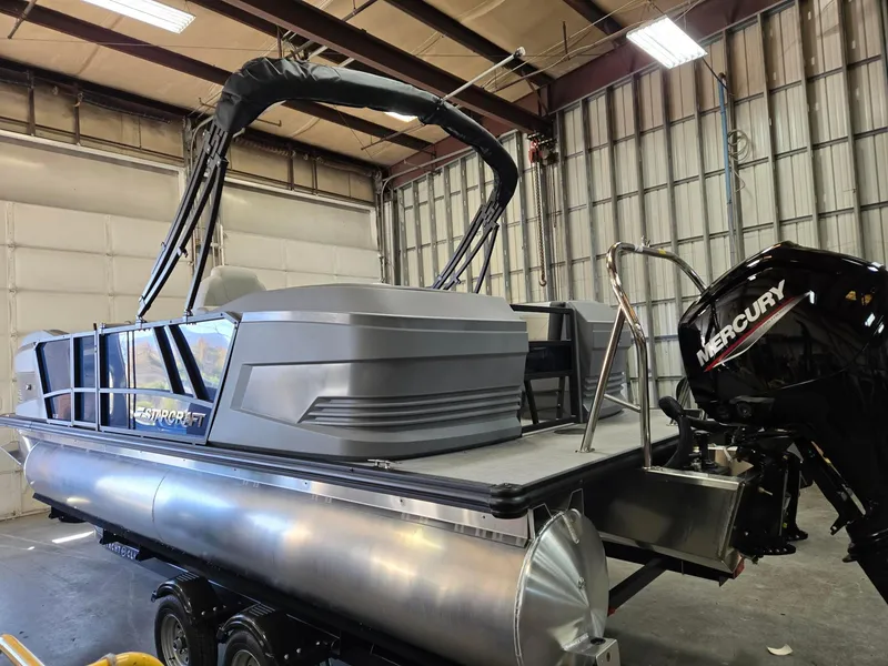 Slide: The Image of 2025 Starcraft GX22R pontoon boat with Mercury engine in a warehouse setting. - 4