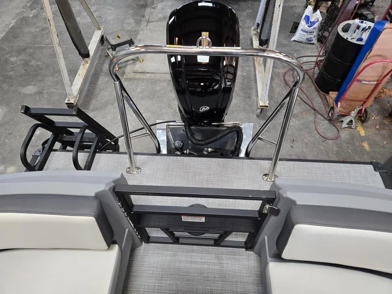 Slide: The Image of 2025 Starcraft GX22R boat interior with motor, railing, and seating in a workshop setting. - 9