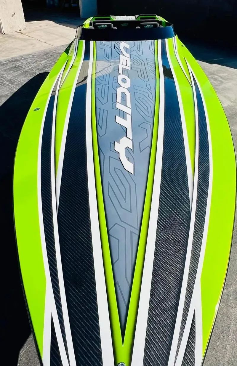 The Image of 2025 Velocity 40 RAPTOR speedboat in vibrant green, docked on a calm lake. - 0