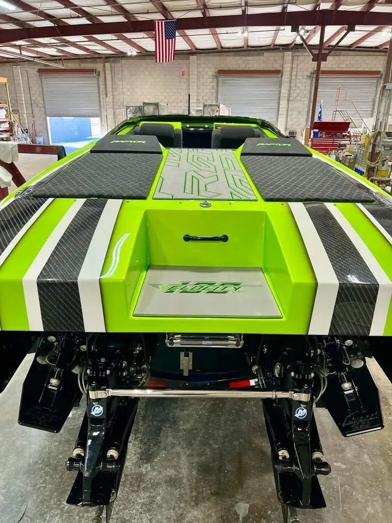 Slide: The Image of 2025 Velocity 40 RAPTOR boat with vibrant green and black design in a workshop setting. - 5
