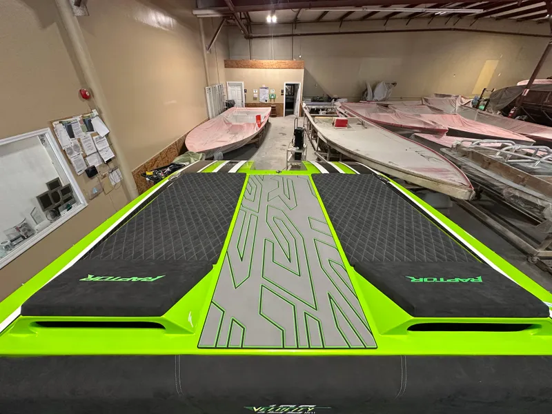 Slide: The Image of 2025 Velocity 40 RAPTOR boat in a workshop, featuring vibrant green and black design. - 8