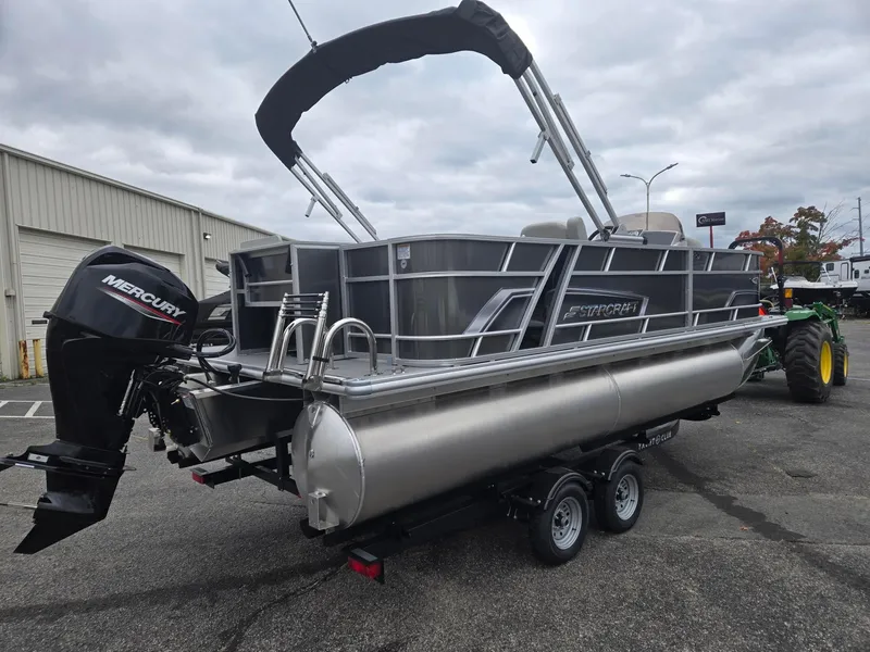 Slide: The Image of 2025 Starcraft EX20FD4 pontoon boat with Mercury outboard motor on trailer. - 3