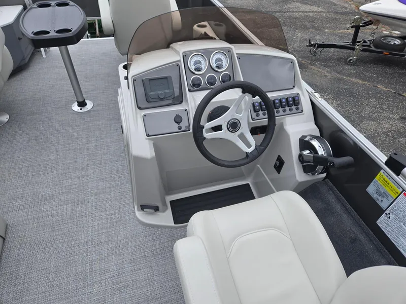 Slide: The Image of 2025 Starcraft EX20FD4 boat cockpit with steering wheel, control panel, and seating. - 7