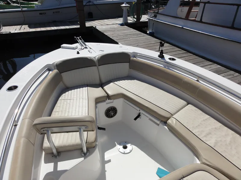 Slide: The Image of 2017 Sea Fox 249 Avenger boat interior with beige seating at a dock. - 11