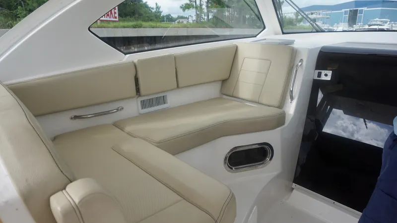 Slide: The Image of 2018 Pursuit OS 355 Offshore boat interior with beige seating and modern design. - 10