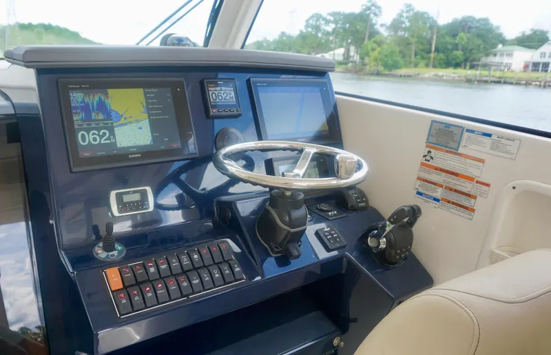 Slide: The Image of 2018 Pursuit OS 355 Offshore helm with navigation screens and controls. - 11