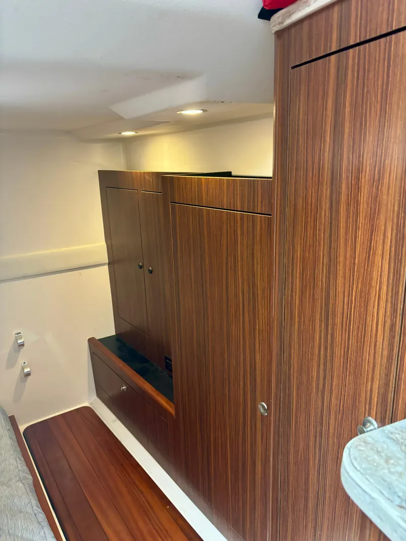 Slide: The Image of 2018 Pursuit OS 355 Offshore cabin interior with wood paneling and storage cabinets. - 13
