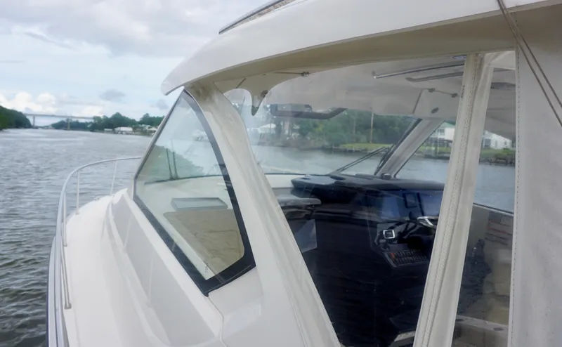 Slide: The Image of 2018 Pursuit OS 355 Offshore boat on a calm river, showcasing sleek design and cockpit. - 9