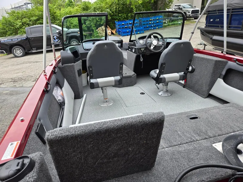 Slide: The Image of 2025 Lowe FS1800 boat interior with dual seats, steering console, and carpeted flooring. - 8