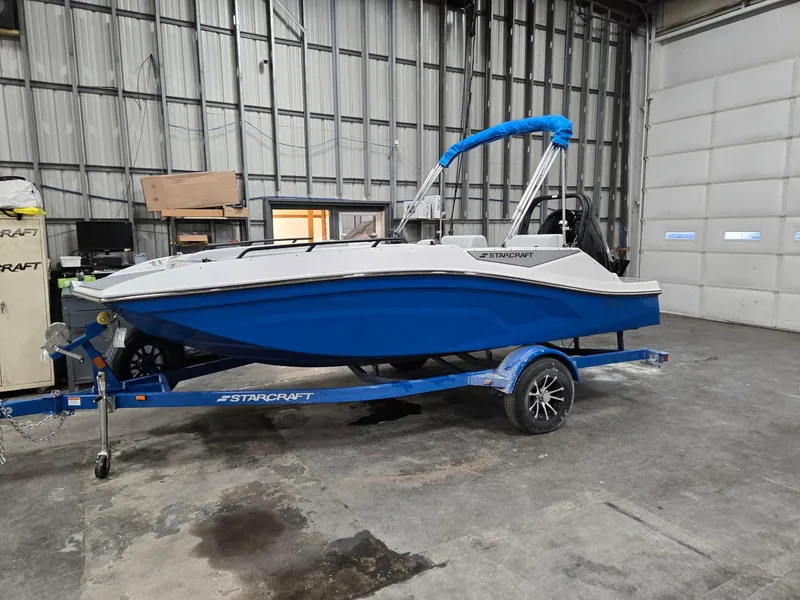 Slide: The Image of 2025 Starcraft SV16OB boat in warehouse, blue hull on trailer. - 1