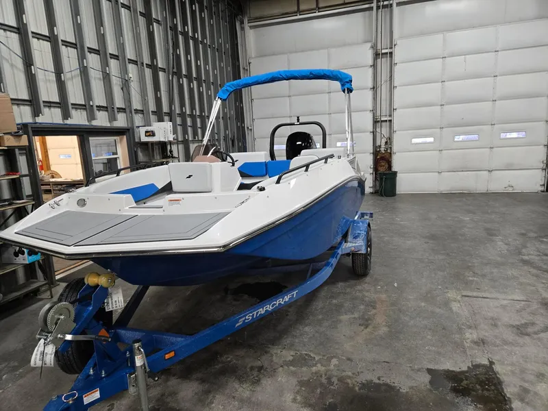 Slide: The Image of 2025 Starcraft SV16OB boat in warehouse, blue and white design on trailer. - 4