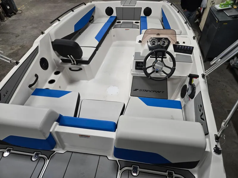 Slide: The Image of 2025 Starcraft SV16OB boat interior with blue and white seating, steering wheel, and dashboard. - 5