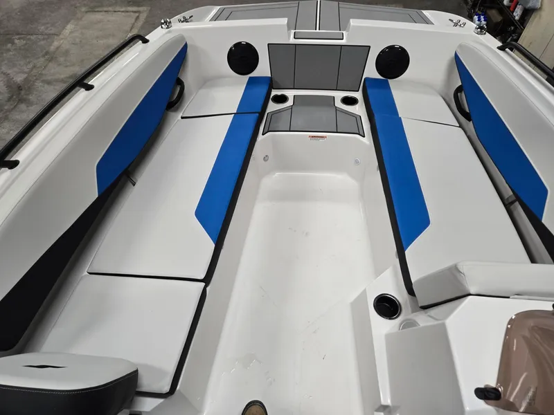 Slide: The Image of 2025 Starcraft SV16OB boat interior with blue and white seating, cup holders, and speakers. - 8