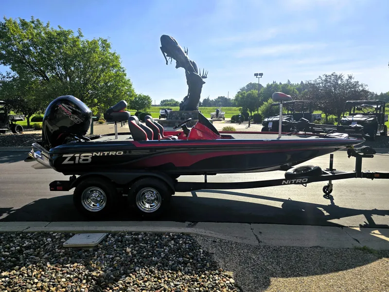 Slide: The Image of 2025 Nitro Z18 Pro boat on trailer, parked outdoors with trees and sculpture in background. - 5