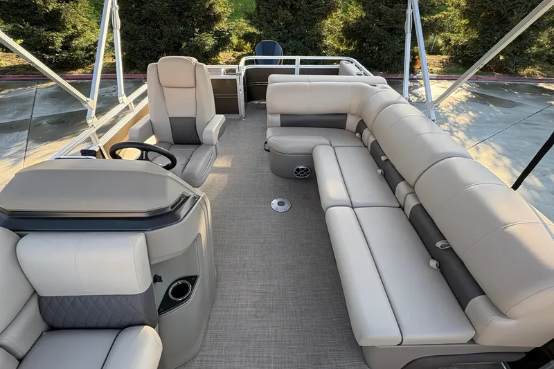 Slide: The Image of 2025 Sun Tracker Sportfish 24 XP3 pontoon boat interior with plush seating and steering console. - 70