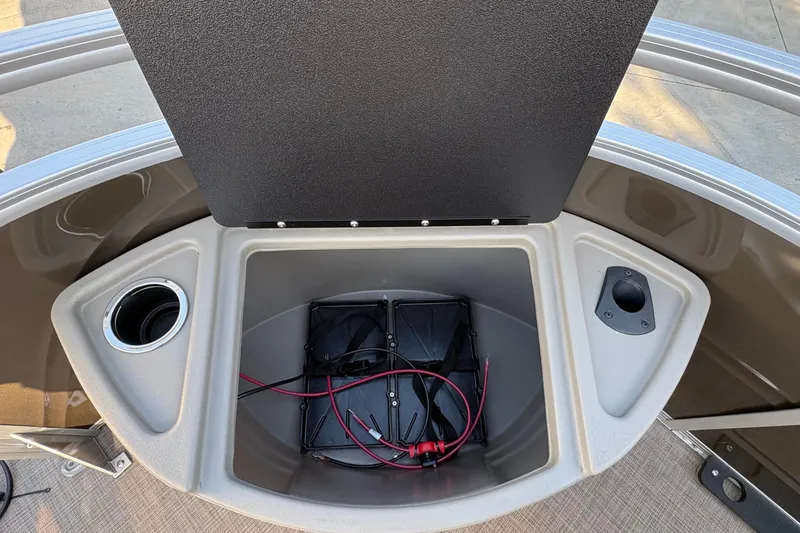 Slide: The Image of 2025 Sun Tracker Sportfish 24 XP3 storage compartment with battery and cup holder. - 73