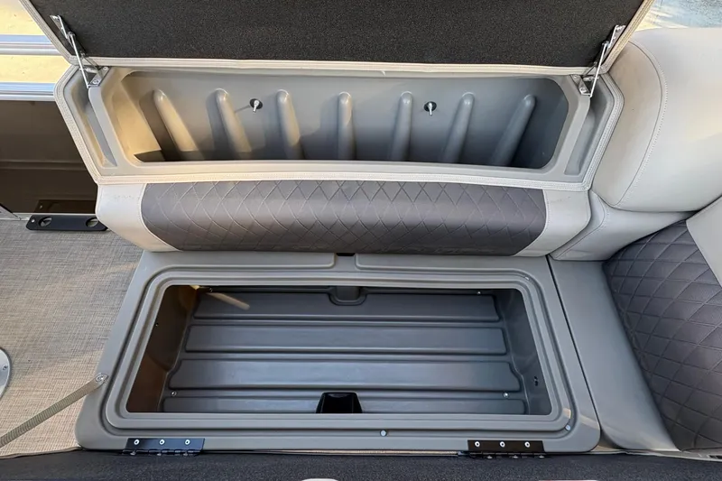 Slide: The Image of 2025 Sun Tracker Sportfish 24 XP3 boat seat storage compartment, open and empty. - 74