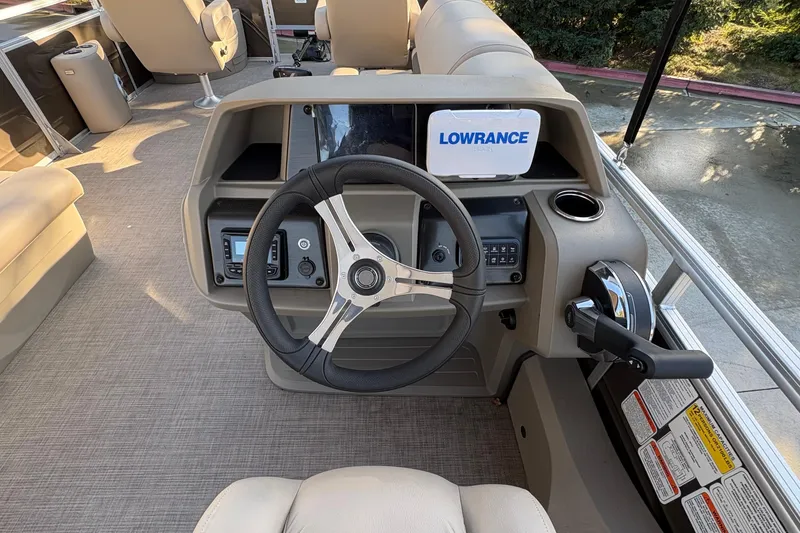 Slide: The Image of 2025 Sun Tracker Sportfish 24 XP3 helm with steering wheel and Lowrance display. - 82