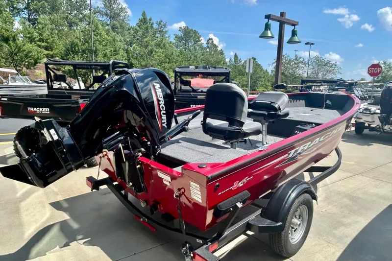 The Image of 2025 Tracker Super Guide V-16 T boat on display, red color, clearance sale sign. - 0