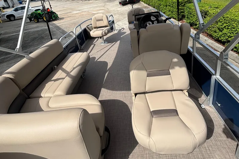 Slide: The Image of 2025 Sun Tracker Bass Buggy 18 DLX pontoon boat interior with beige seating and steering console. - 2
