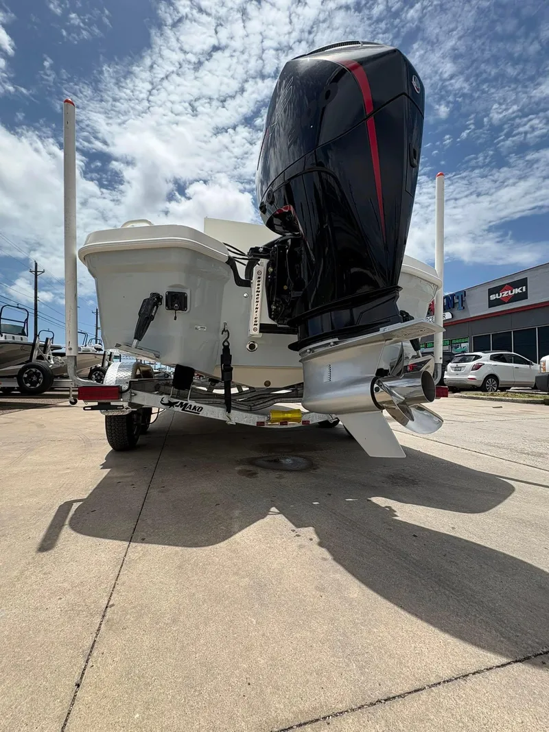Slide: The Image of 2025 Mako 24 APEX boat with powerful outboard motor, parked outdoors under a cloudy sky. - 7