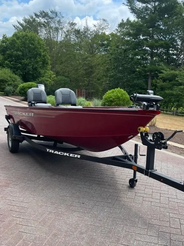 Slide: The Image of 2025 Tracker Super Guide V-16 T boat on trailer, parked on brick road. - 2