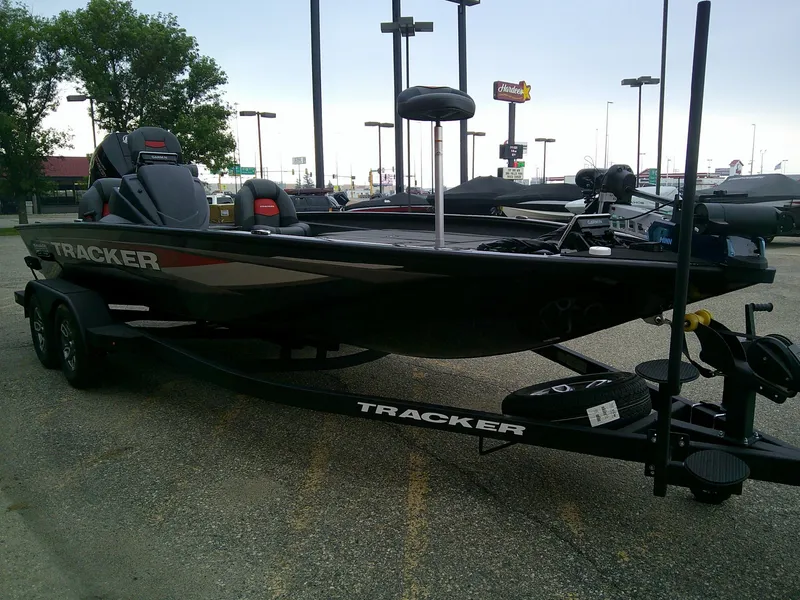 Slide: The Image of 2025 Tracker Savage 215 boat on trailer in parking lot. - 2