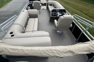 Slide: The Image of 2025 Sun Tracker SportFish 20 DLX pontoon boat interior with plush seating and steering console. - 2