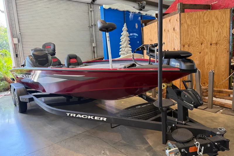 The Image of 2025 Tracker Savage 215 boat in a garage, featuring a sleek red design. - 0